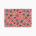 Patterned paper placemat with a red and white checkered background and various food illustrations on a white background