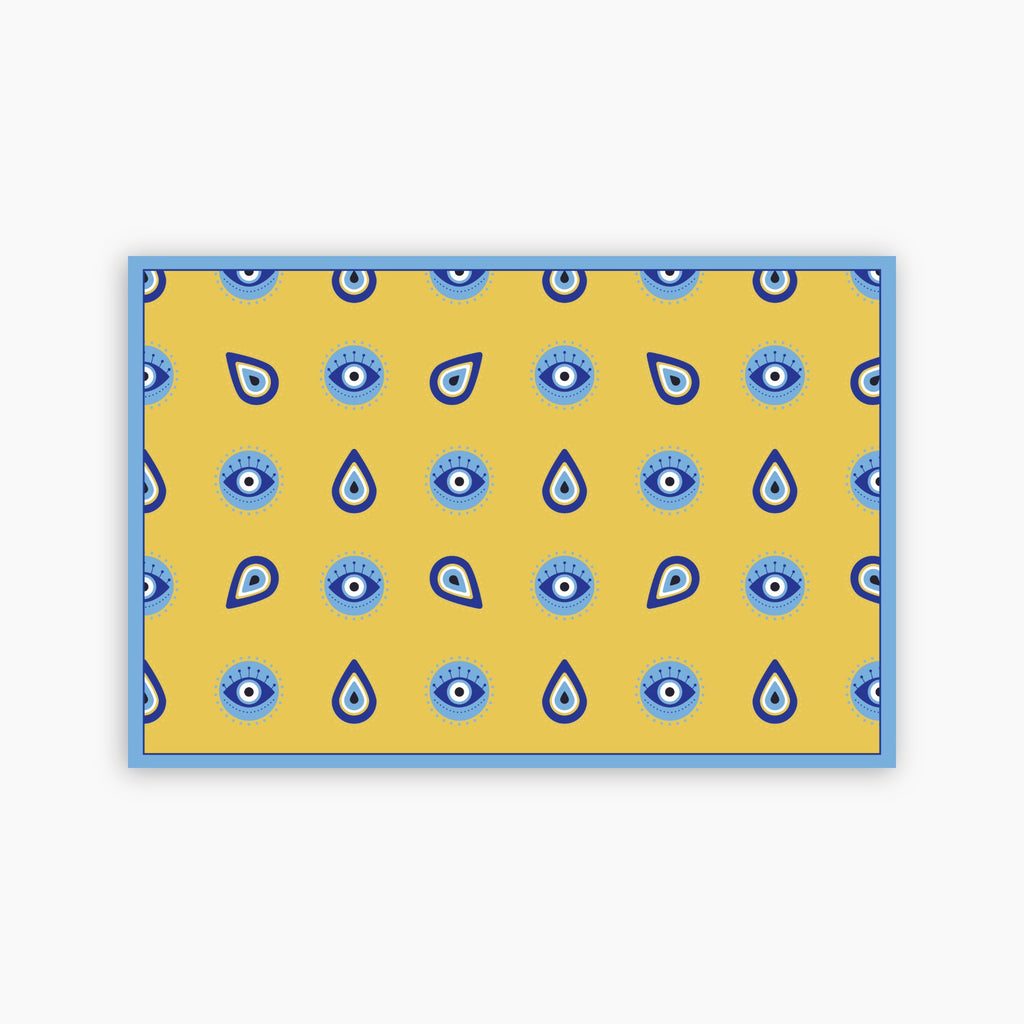 Yellow paper placemat with blue eye pattern on a white background
