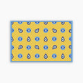 Yellow paper placemat with blue eye pattern on a white background