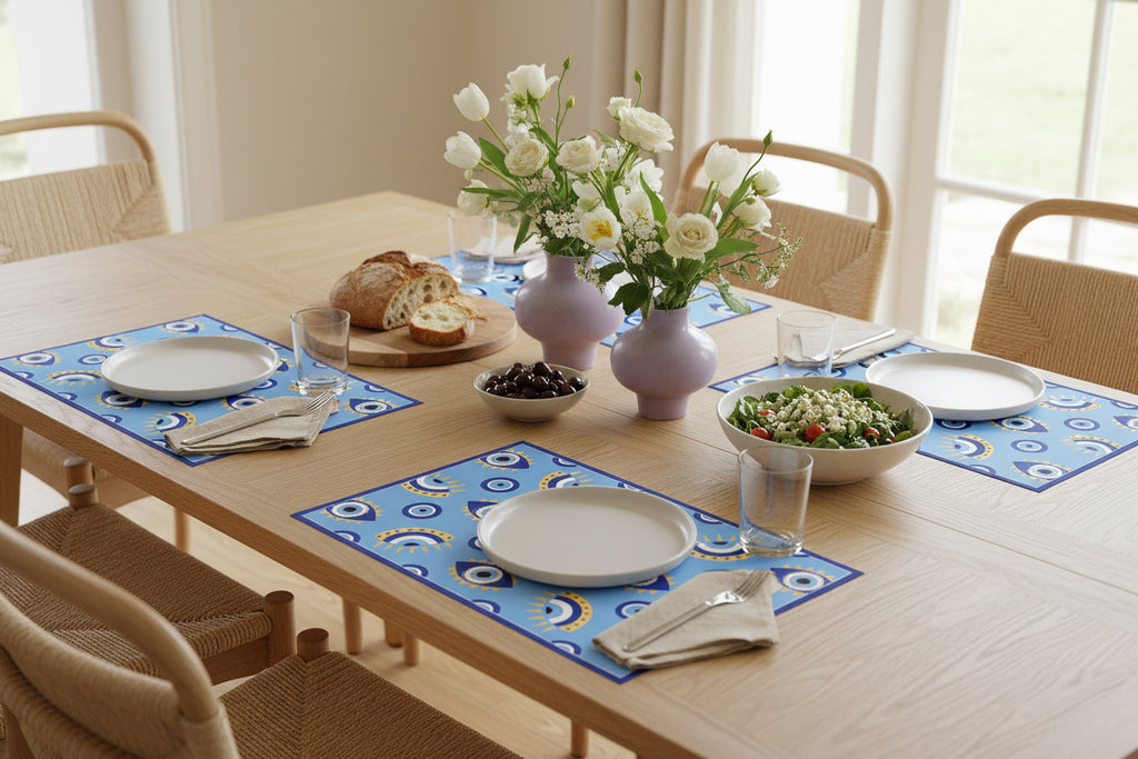 Dining table set with plates, bread, flowers, and salad in a bright room.