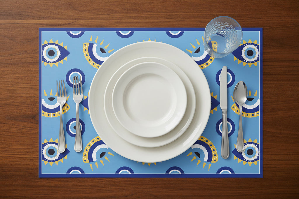 Dinner setting with white plates, silverware, and a blue placemat with geometric patterns on a wooden table.