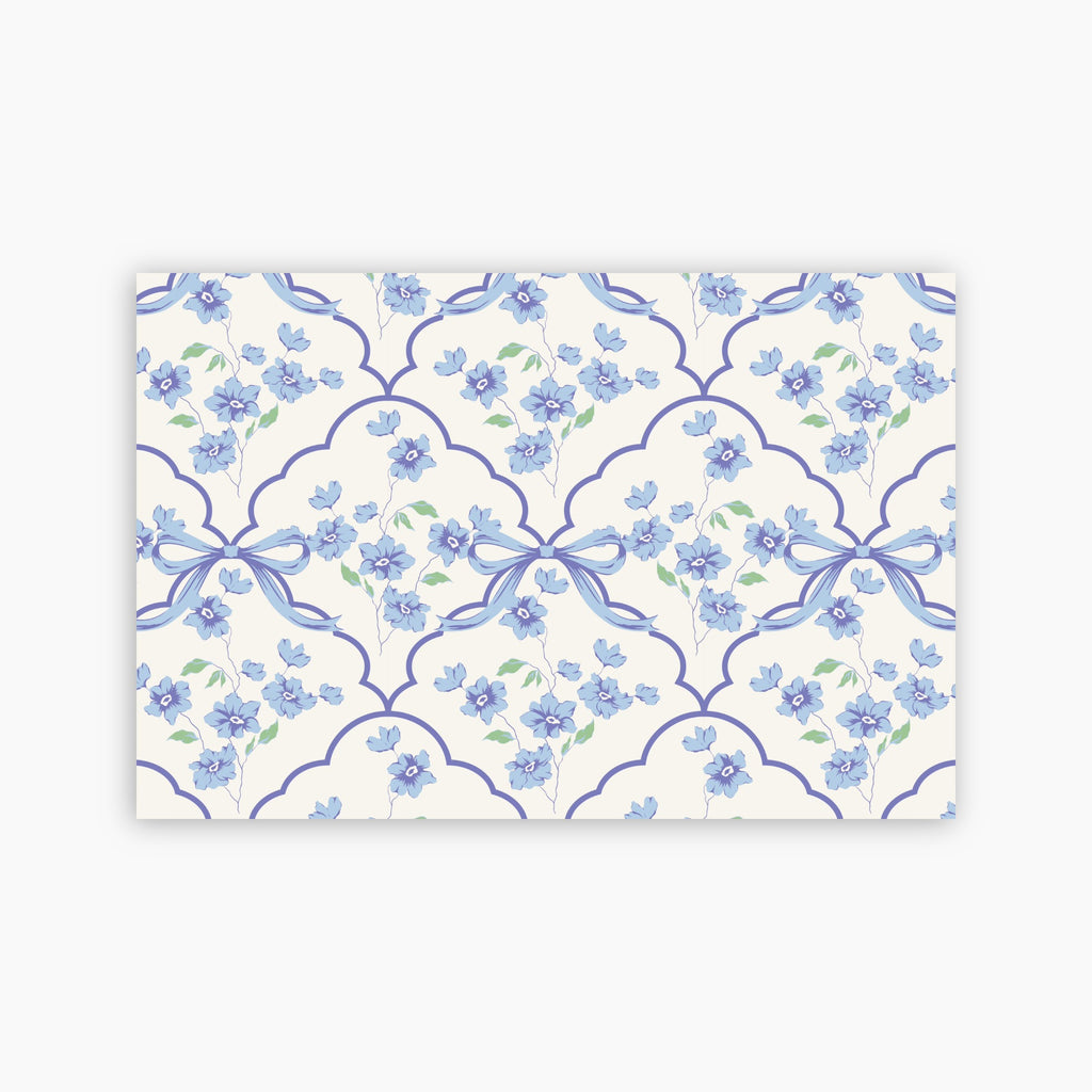Patterned paper with blue flowers and ribbons on a white background