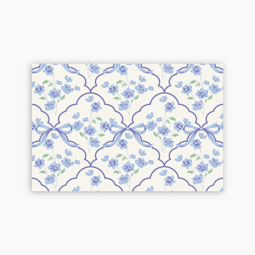 Patterned paper with blue flowers and ribbons on a white background