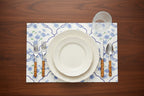 Dinner setting with floral placemat on a wooden table