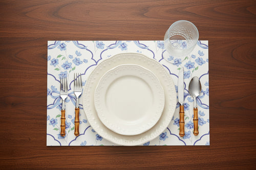 Dinner setting with floral placemat on a wooden table