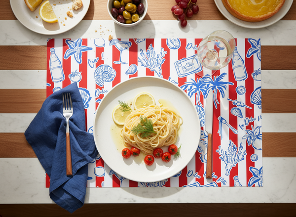 Plate of pasta with lemon and tomatoes on a red and white striped placemat with blue sea-themed design.