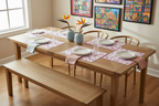 Wooden dining table set with chairs and a bench, placed in a room with a window. The table is set with a purple and lavender placemat showcasing orchid flowers, with plates and a vase in the middle of the table. 